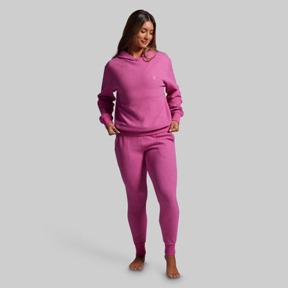 Woman wearing a pink pajama set on a gray background