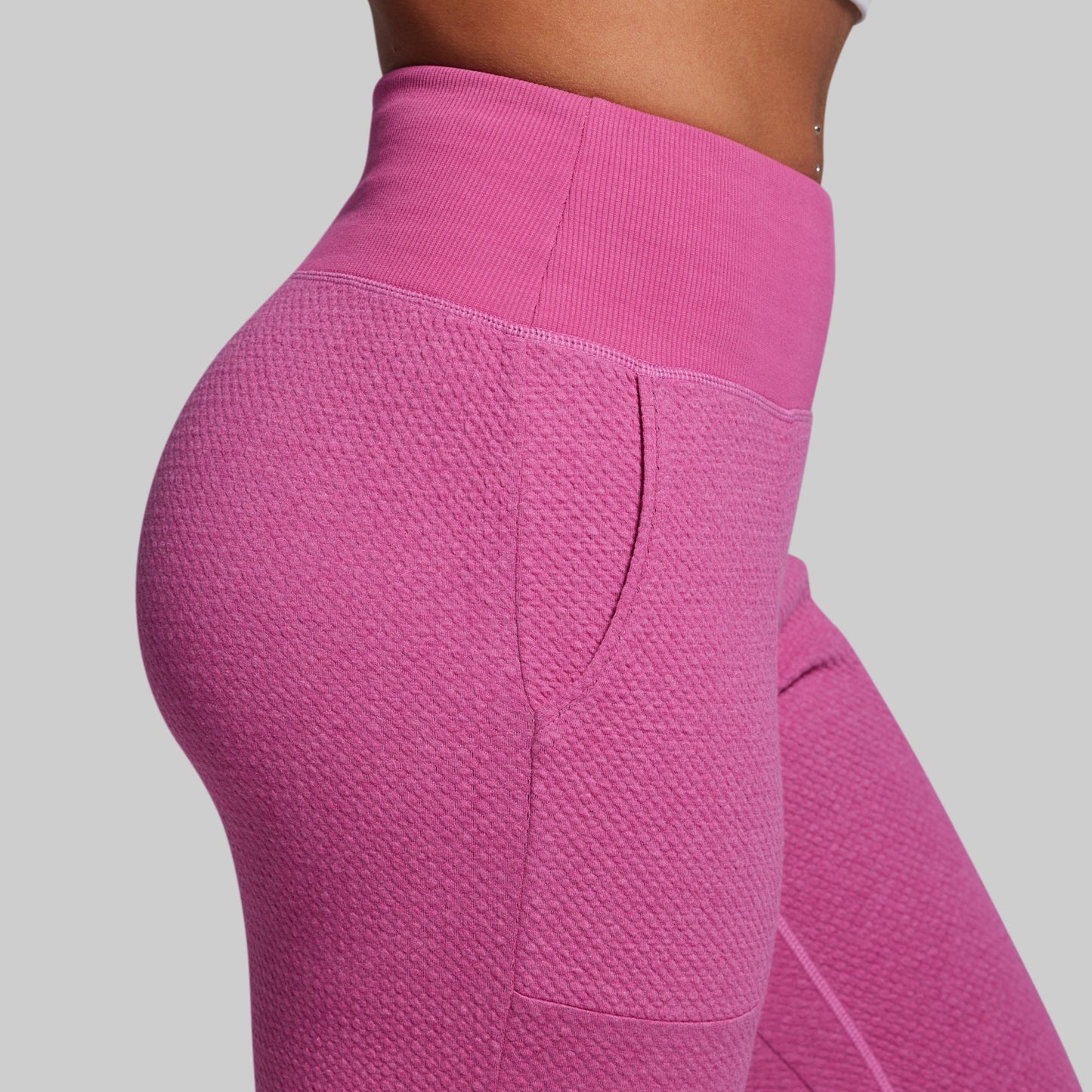 Close-up of pink textured leggings on a plain background