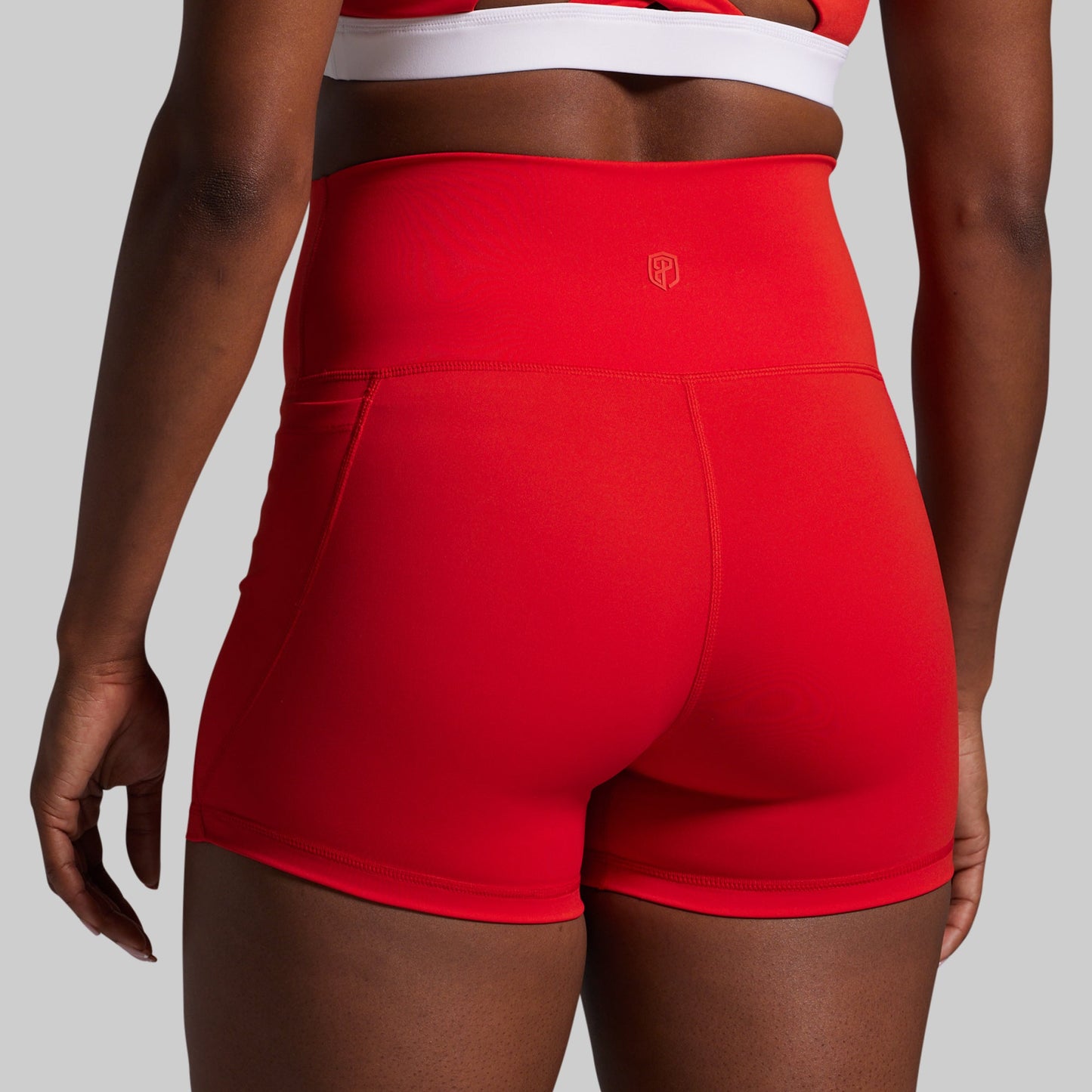 Red athletic shorts worn by a person on a gray background