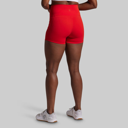 Person wearing red athletic shorts on a gray background