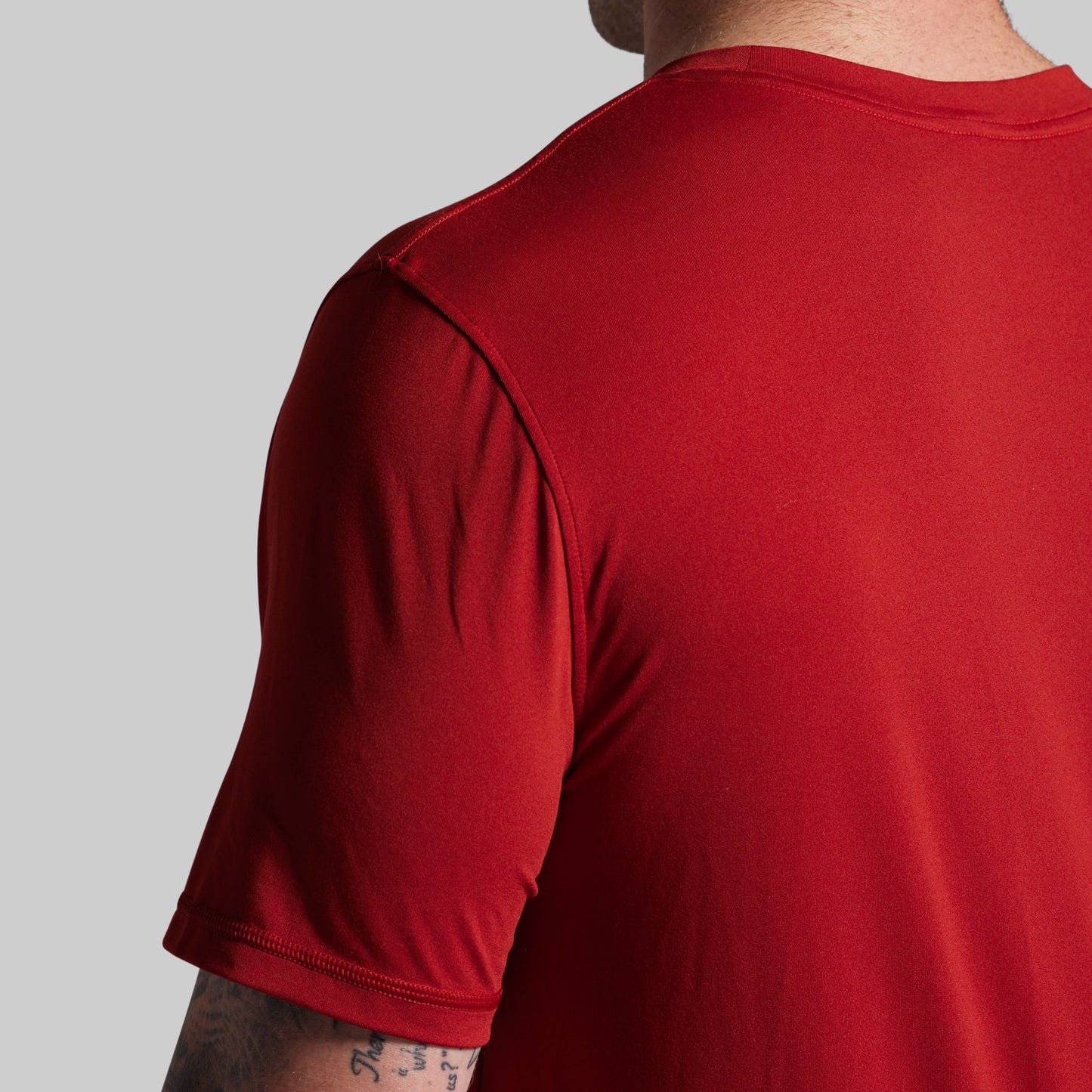 Red t-shirt worn by a person on a gray background