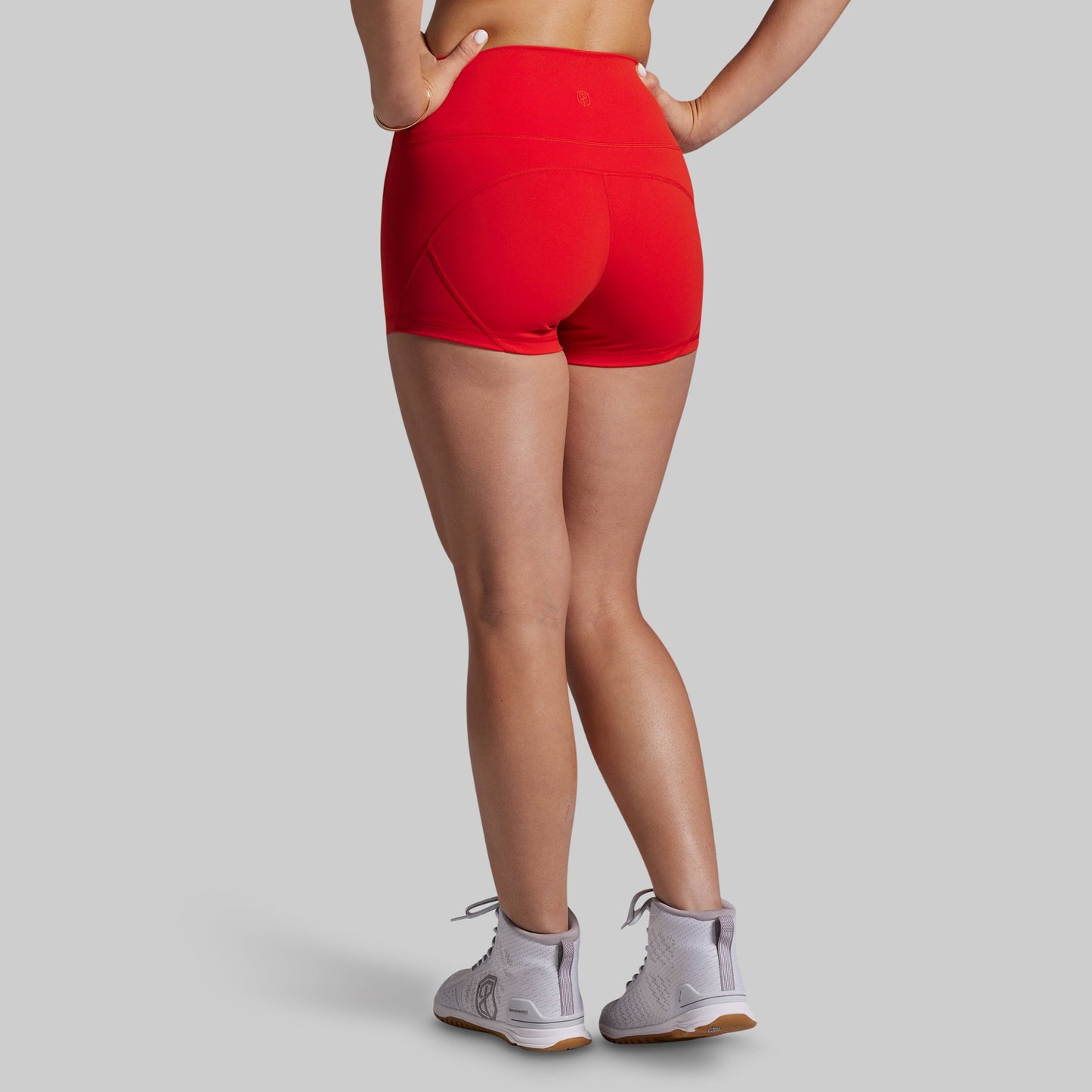 Person wearing red athletic shorts on a gray background