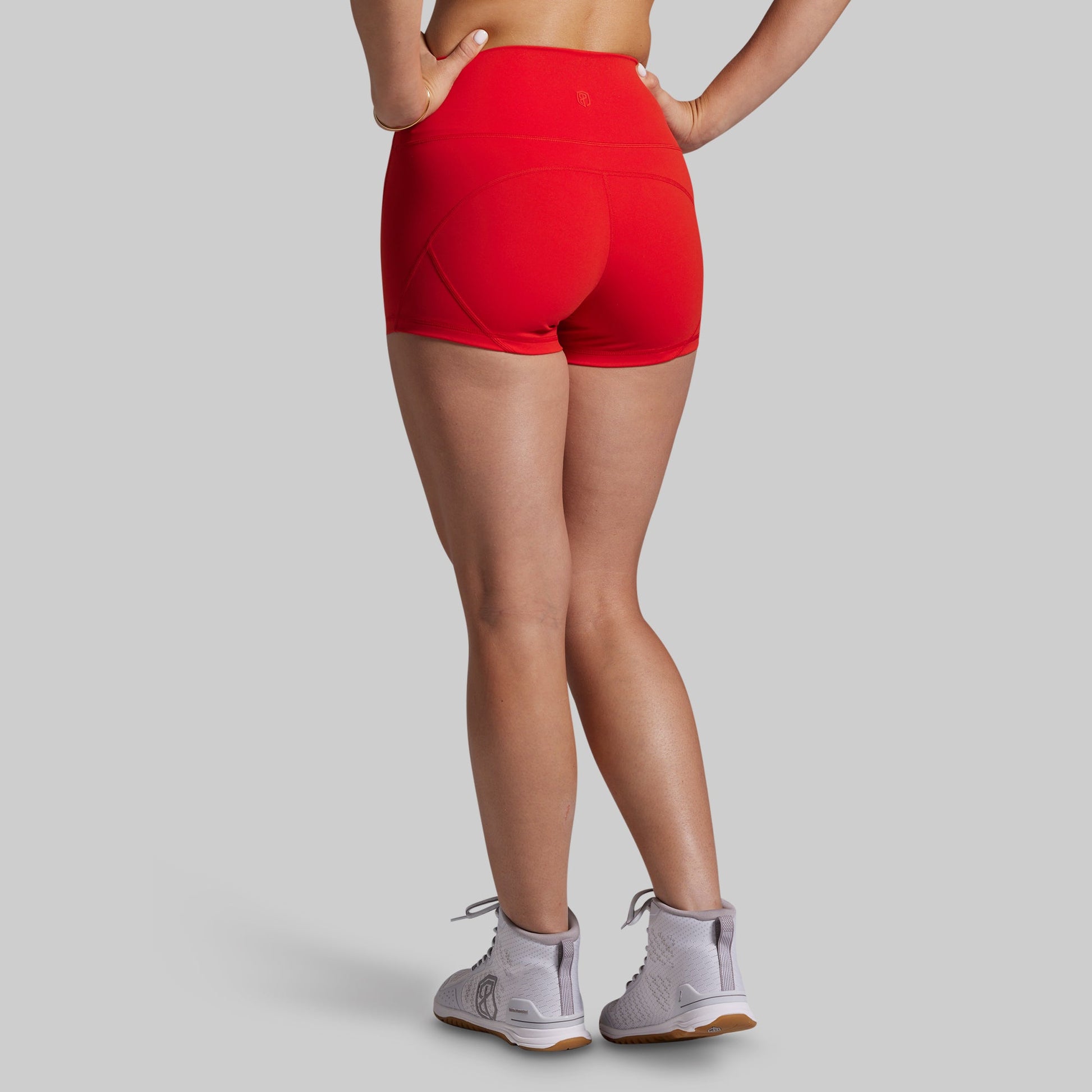 Person wearing red athletic shorts on a gray background