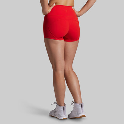 Person wearing red athletic shorts on a gray background