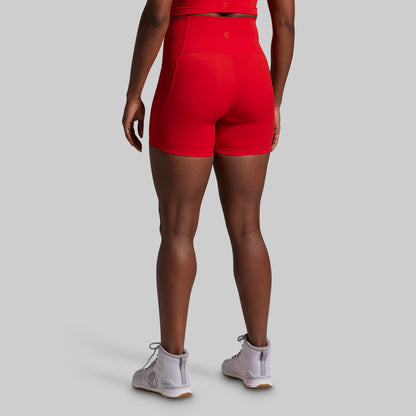 Person wearing red athletic shorts on a gray background
