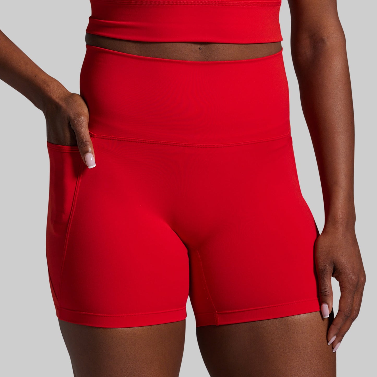 Red athletic shorts worn by a person on a gray background