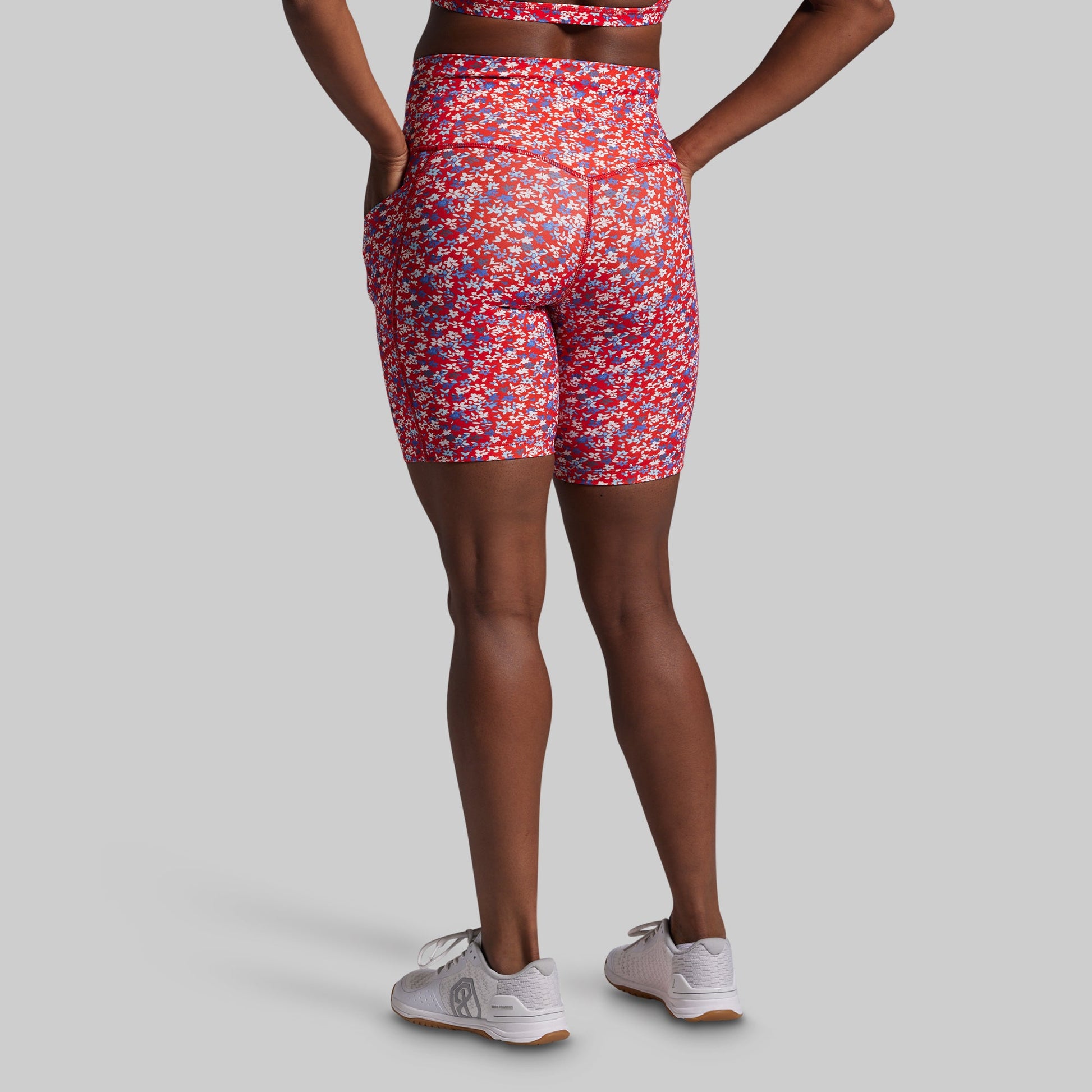Person wearing red patterned shorts on a gray background