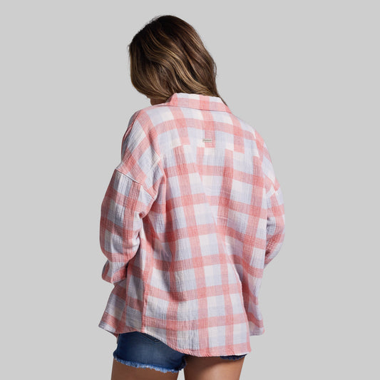 Person wearing a pink and white plaid shirt on a plain background