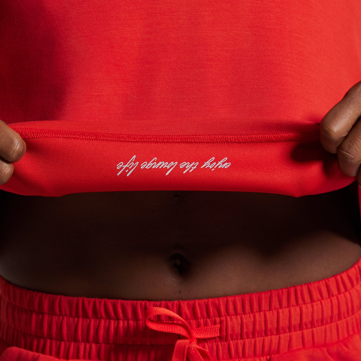 Red athletic outfit with white text on waistband