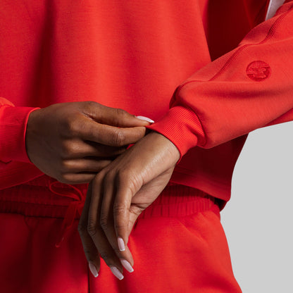 Red sweatshirt with a brand logo on a gray background