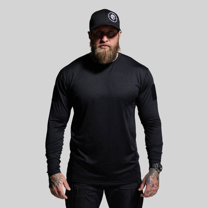 Man wearing a black long-sleeve shirt and cap on a gray background