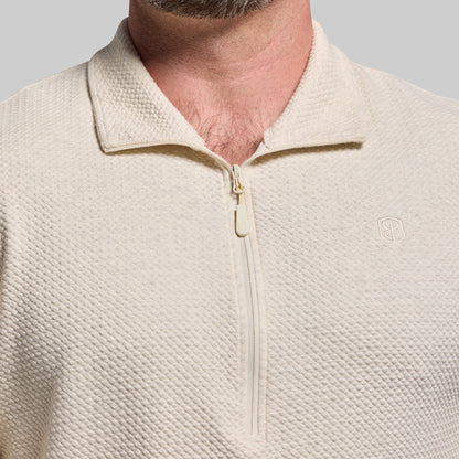Close-up of a beige pullover with a zipper on a gray background