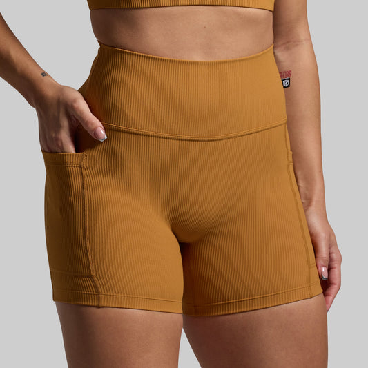 Mustard yellow ribbed shorts worn by a person on a plain background