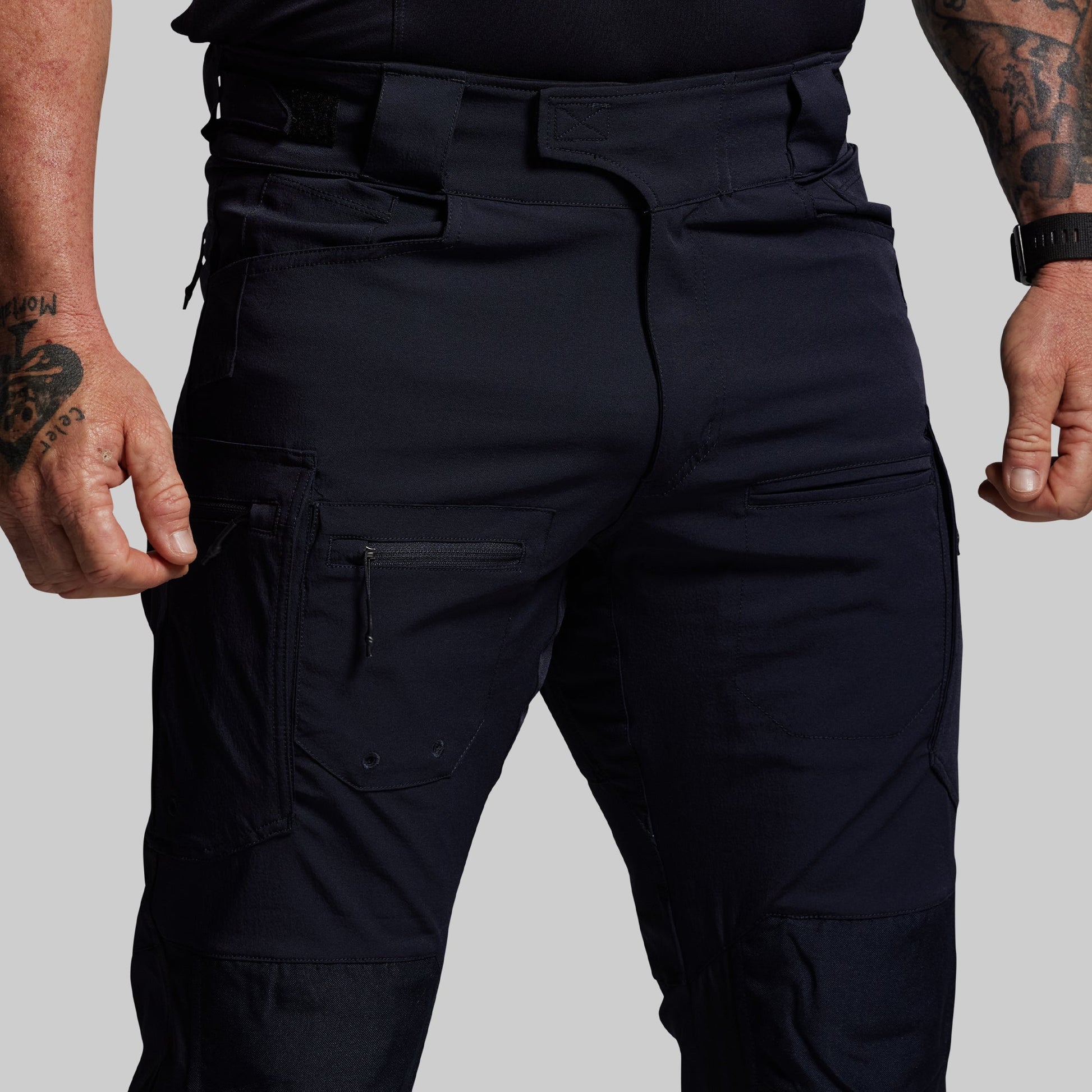Blue tactical pants worn by a person on a plain background