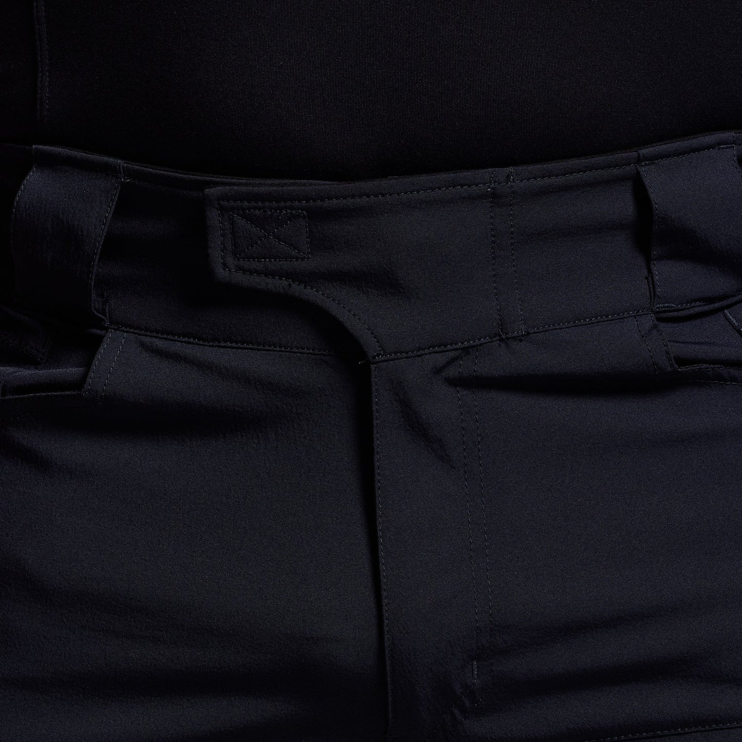 Close-up of blue pants with a focus on the waistband and pocket area.