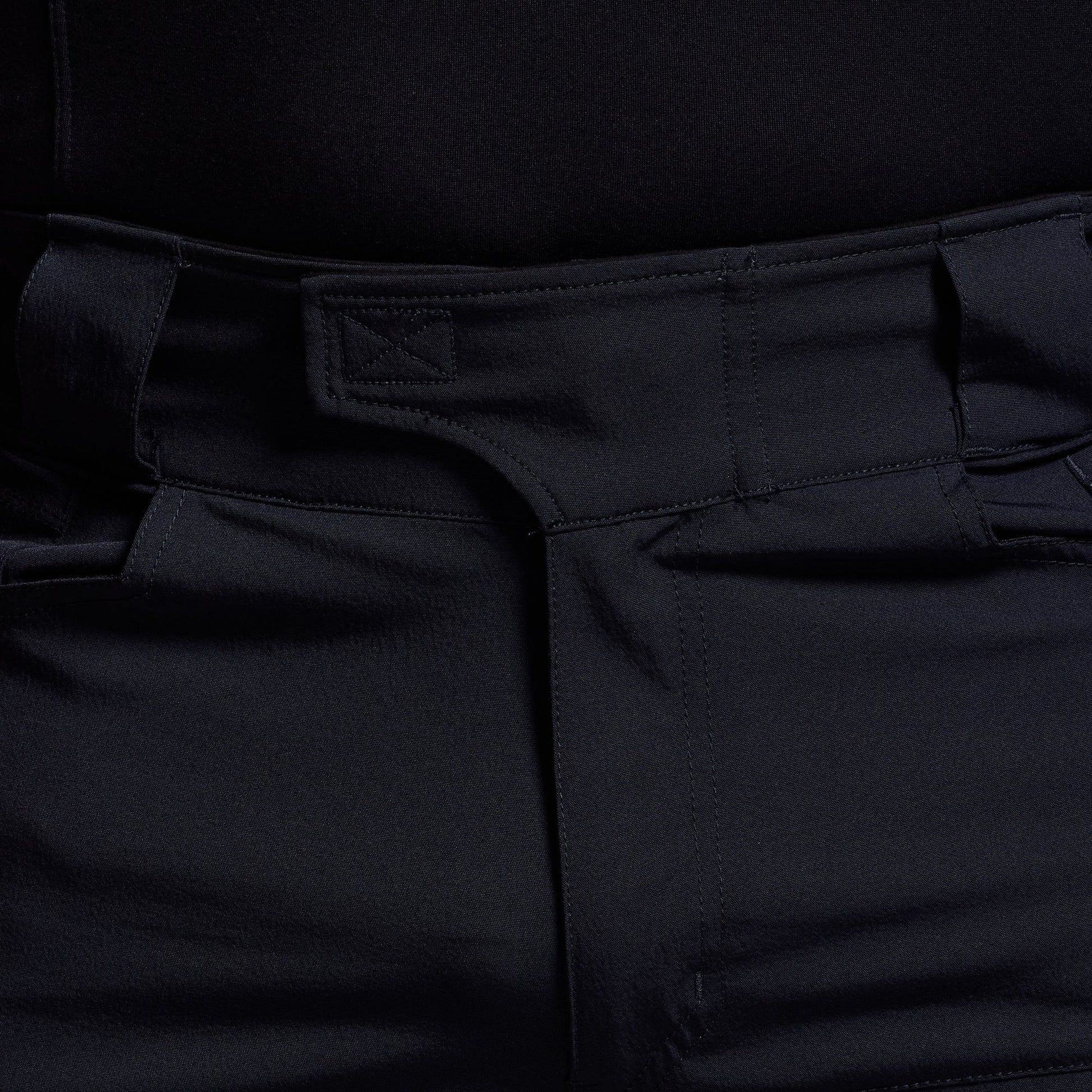 Close-up of blue pants with a focus on the waistband and pocket area.