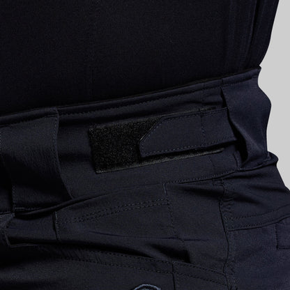 Close-up of blue tactical pants with an adjustable waistband on a gray background