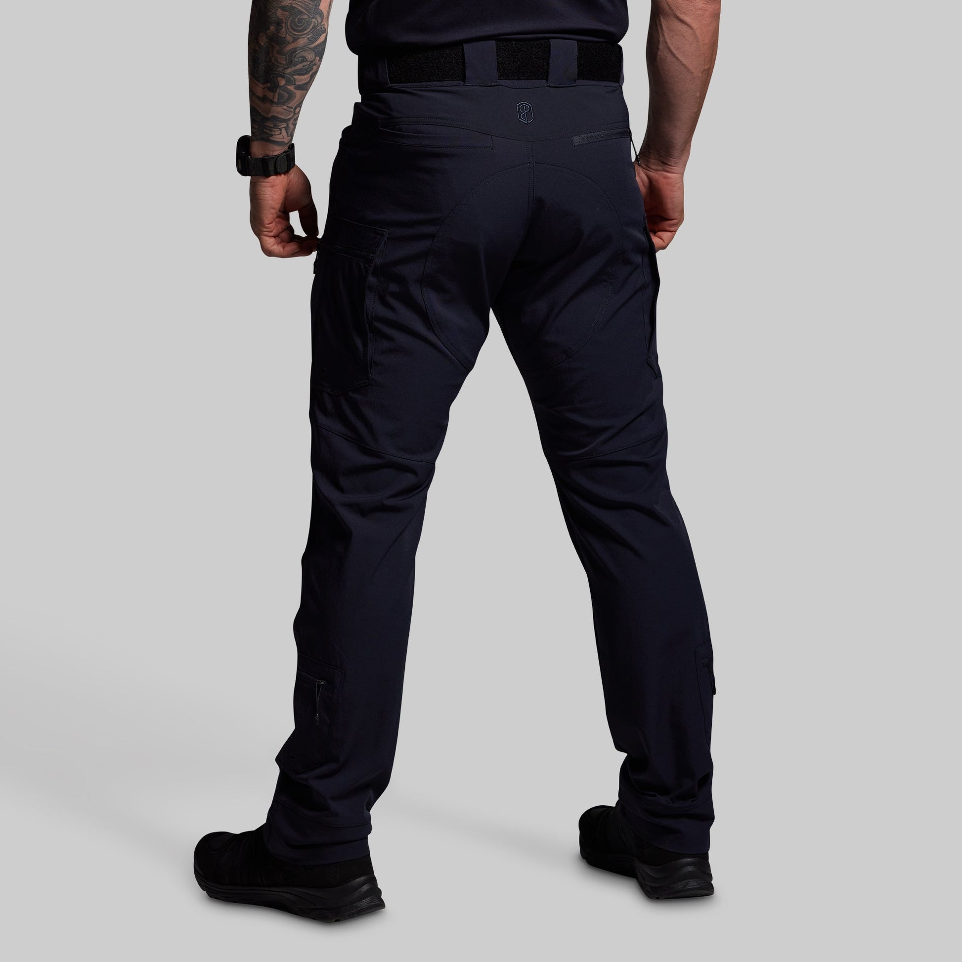 Person wearing blue tactical pants on a gray background