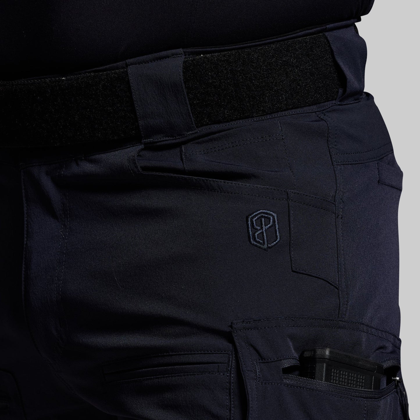 Blue tactical pants with a visible brand logo on a gray background