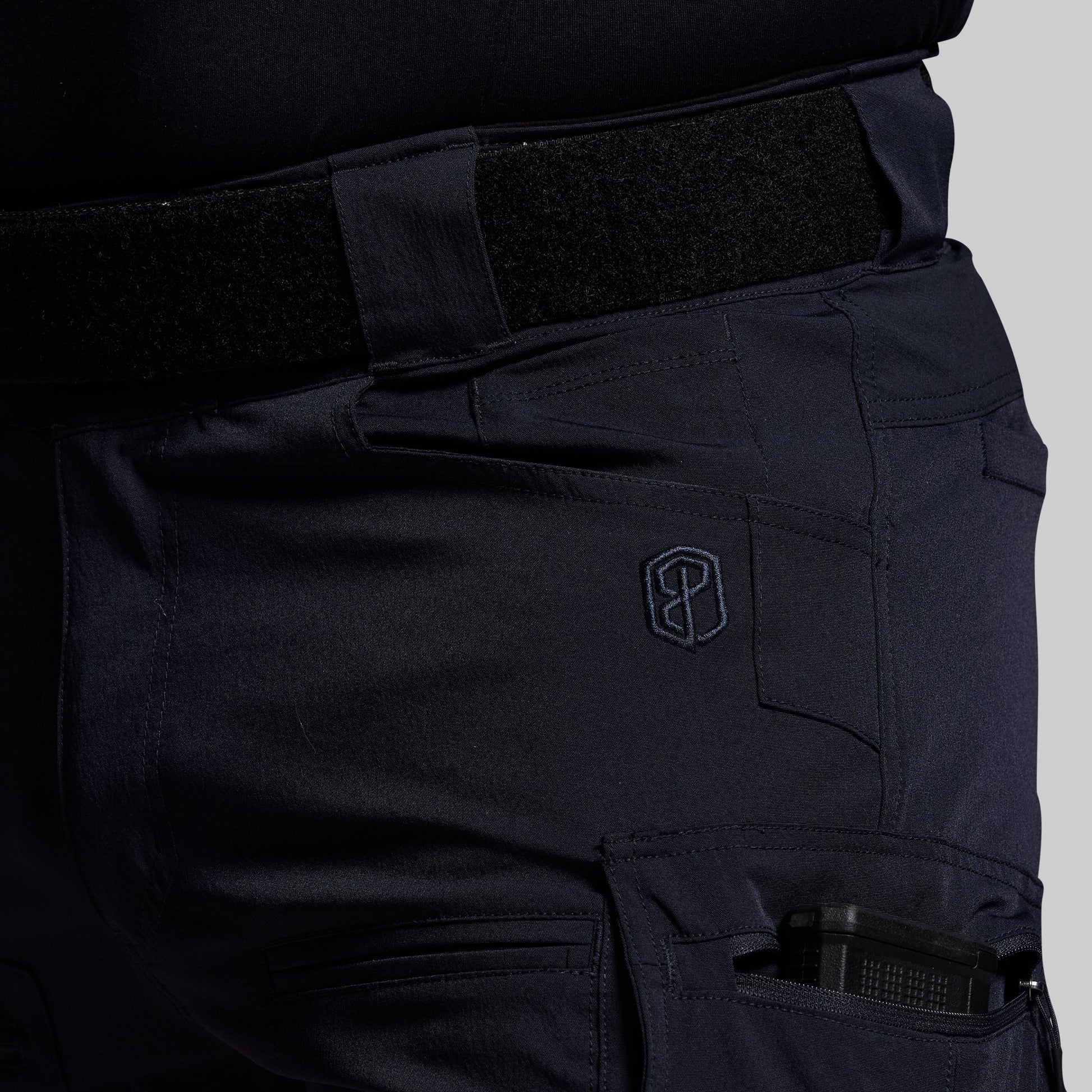 Blue tactical pants with a visible brand logo on a gray background