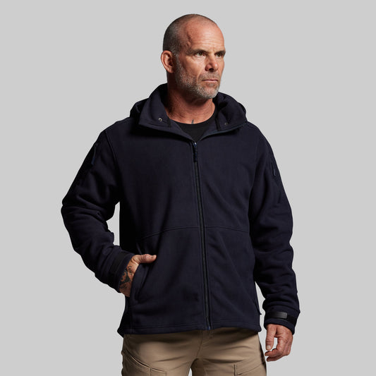 Man wearing a dark blue jacket on a gray background