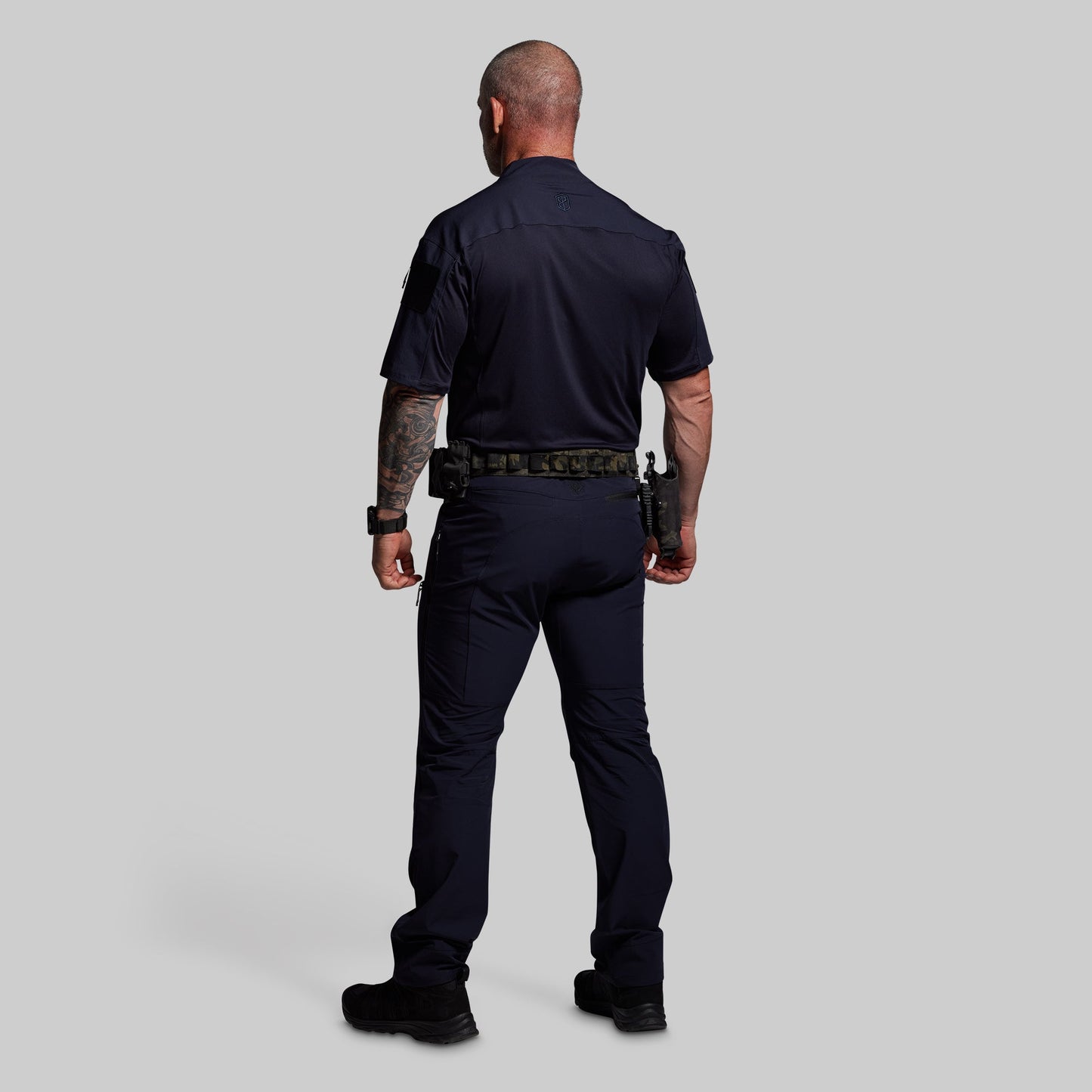Person wearing a navy blue police uniform on a gray background