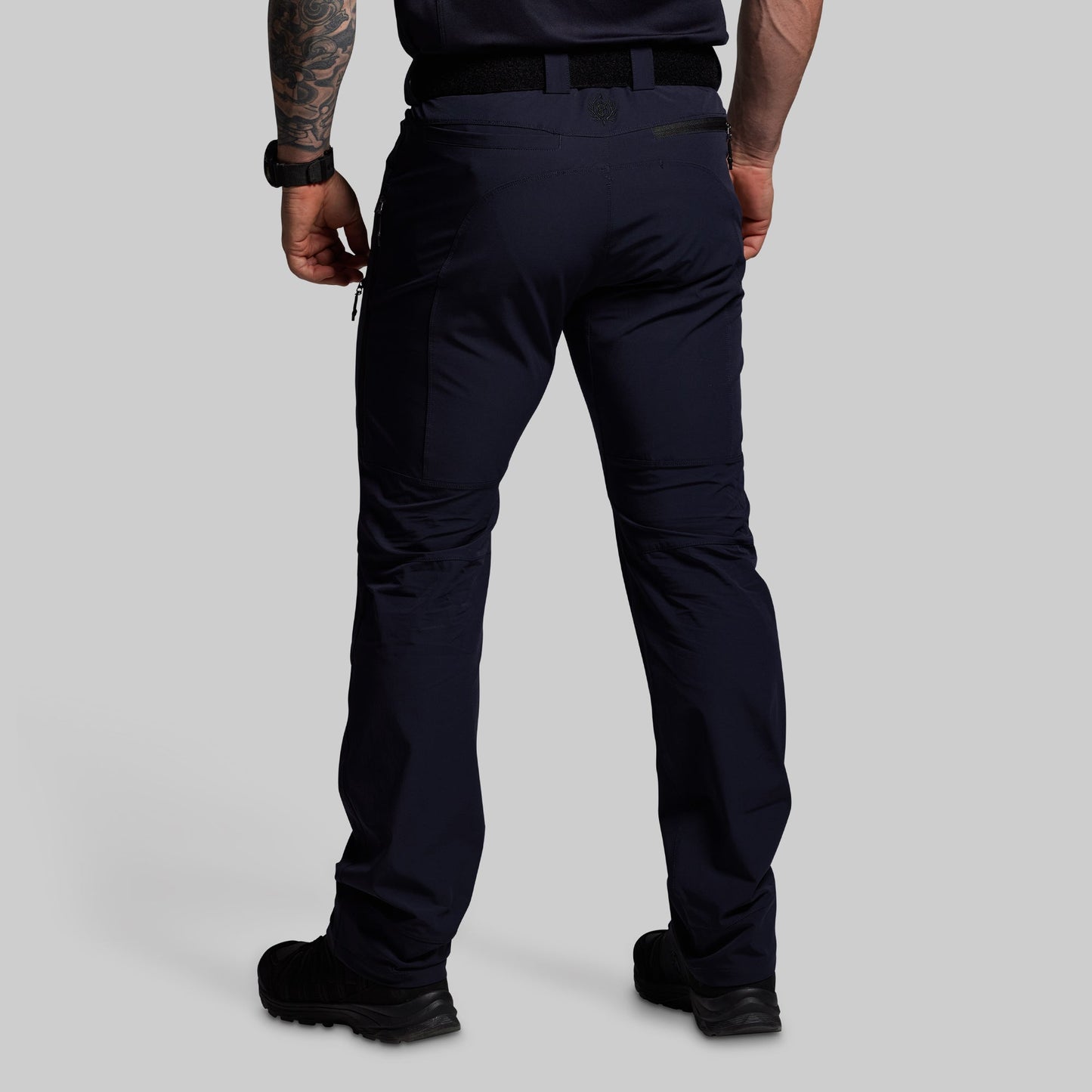 Person wearing dark blue pants on a gray background