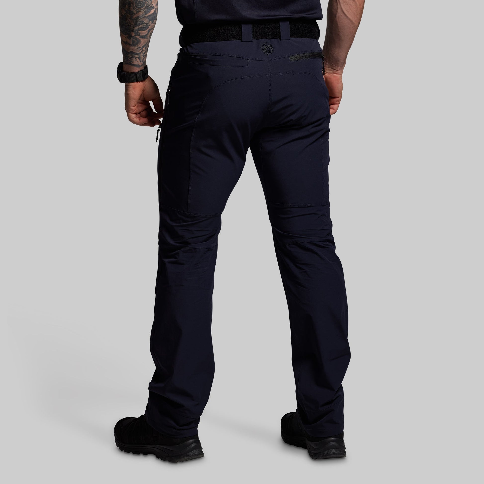 Person wearing dark blue pants on a gray background