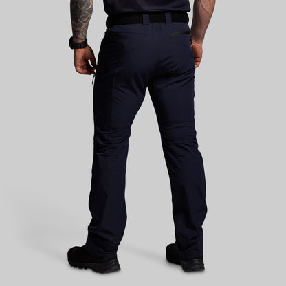 Person wearing dark blue pants on a gray background