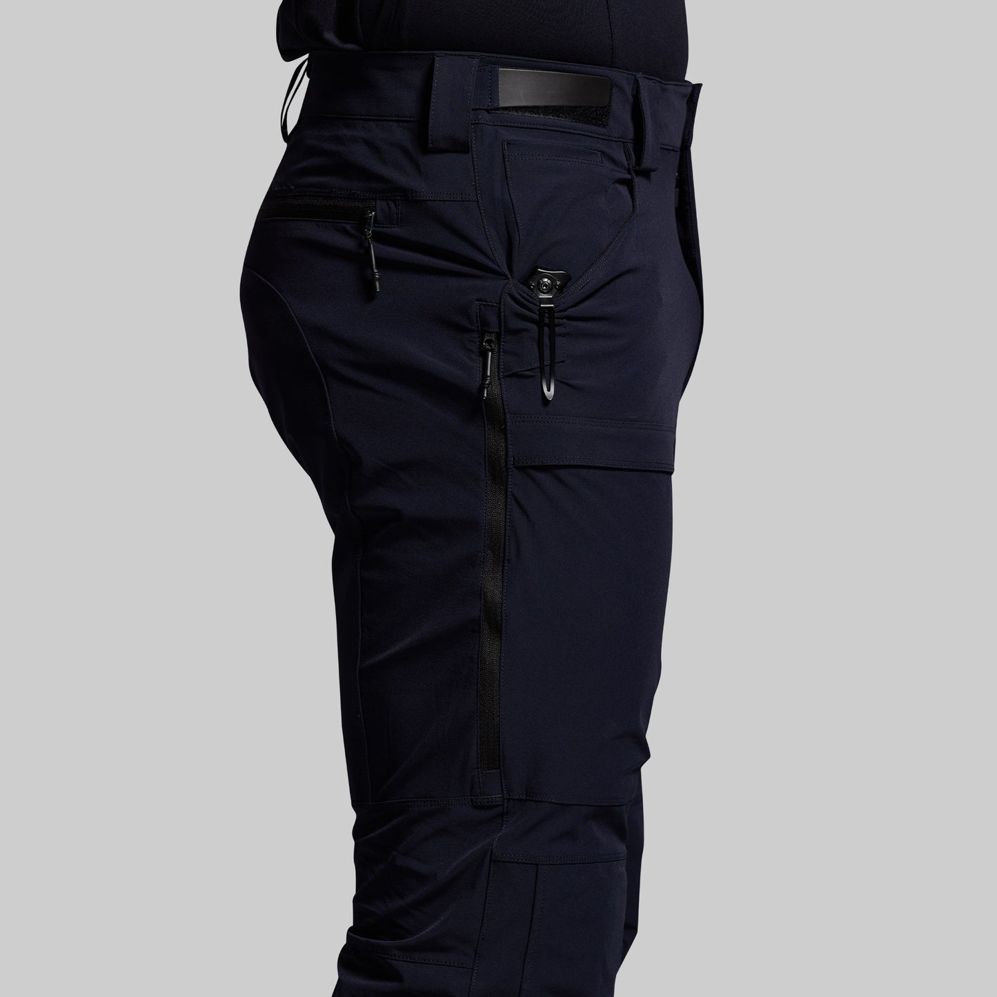 Blue outdoor pants with multiple pockets on a gray background