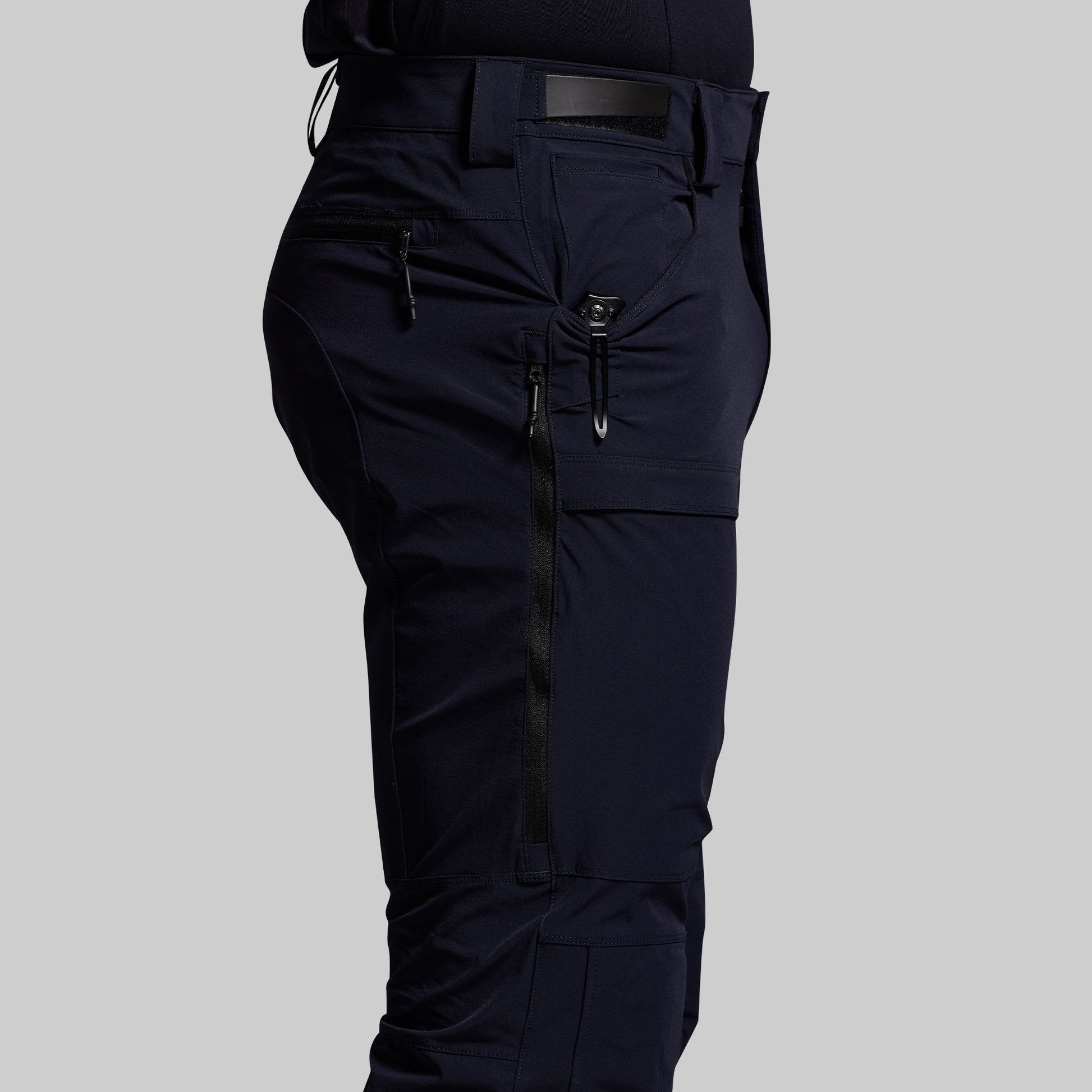 Blue outdoor pants with multiple pockets on a gray background