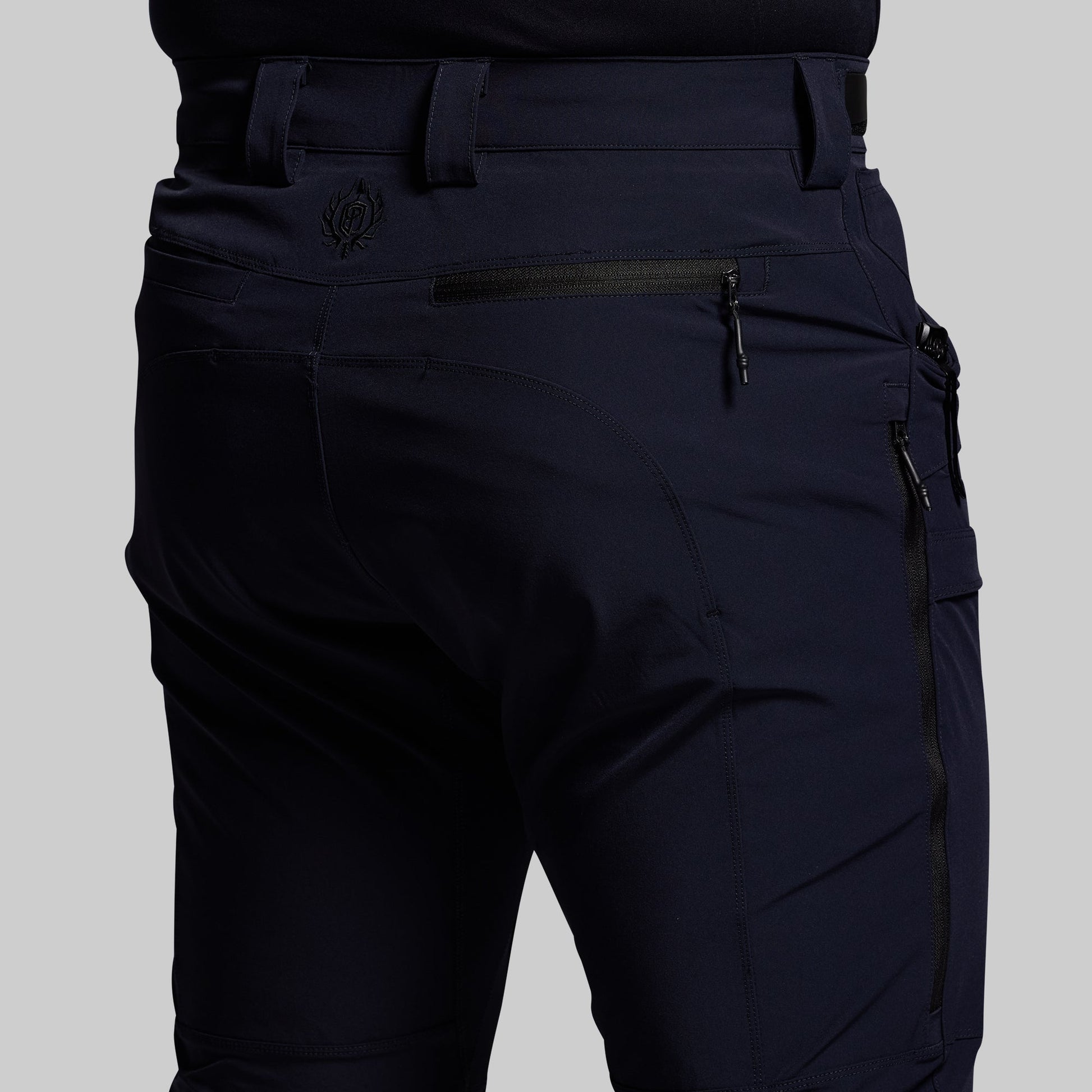 Blue outdoor pants with multiple pockets on a gray background