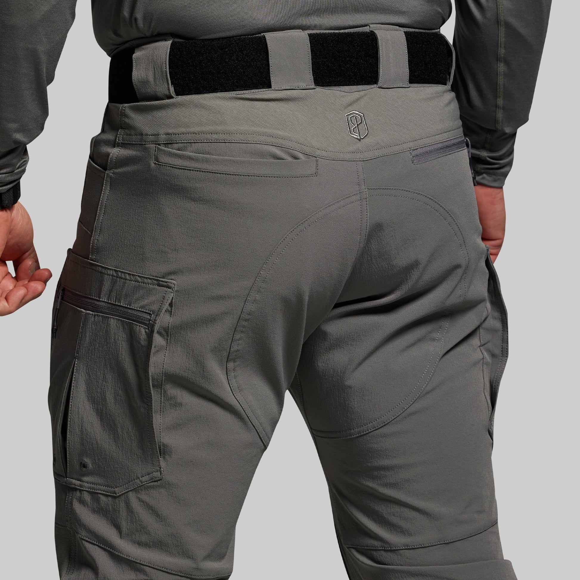 Gray tactical pants with a belt on a gray background