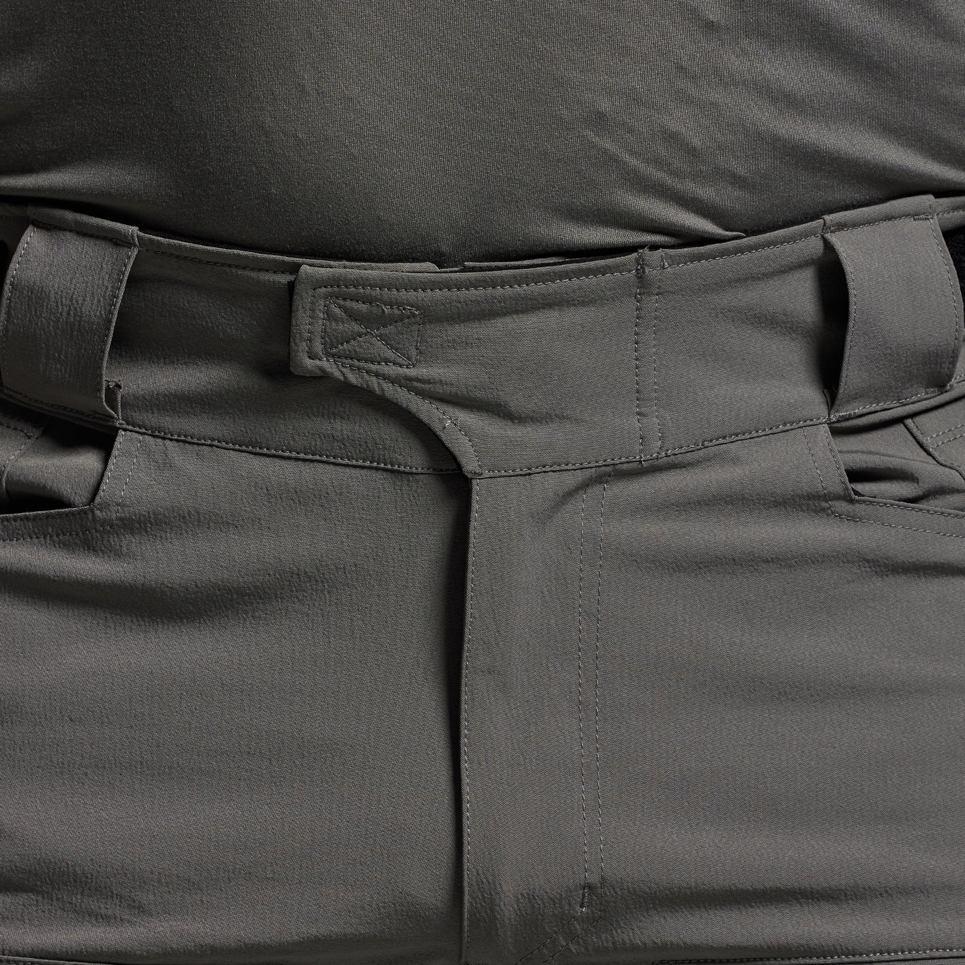 Close-up of dark gray tactical pants with multiple pockets.