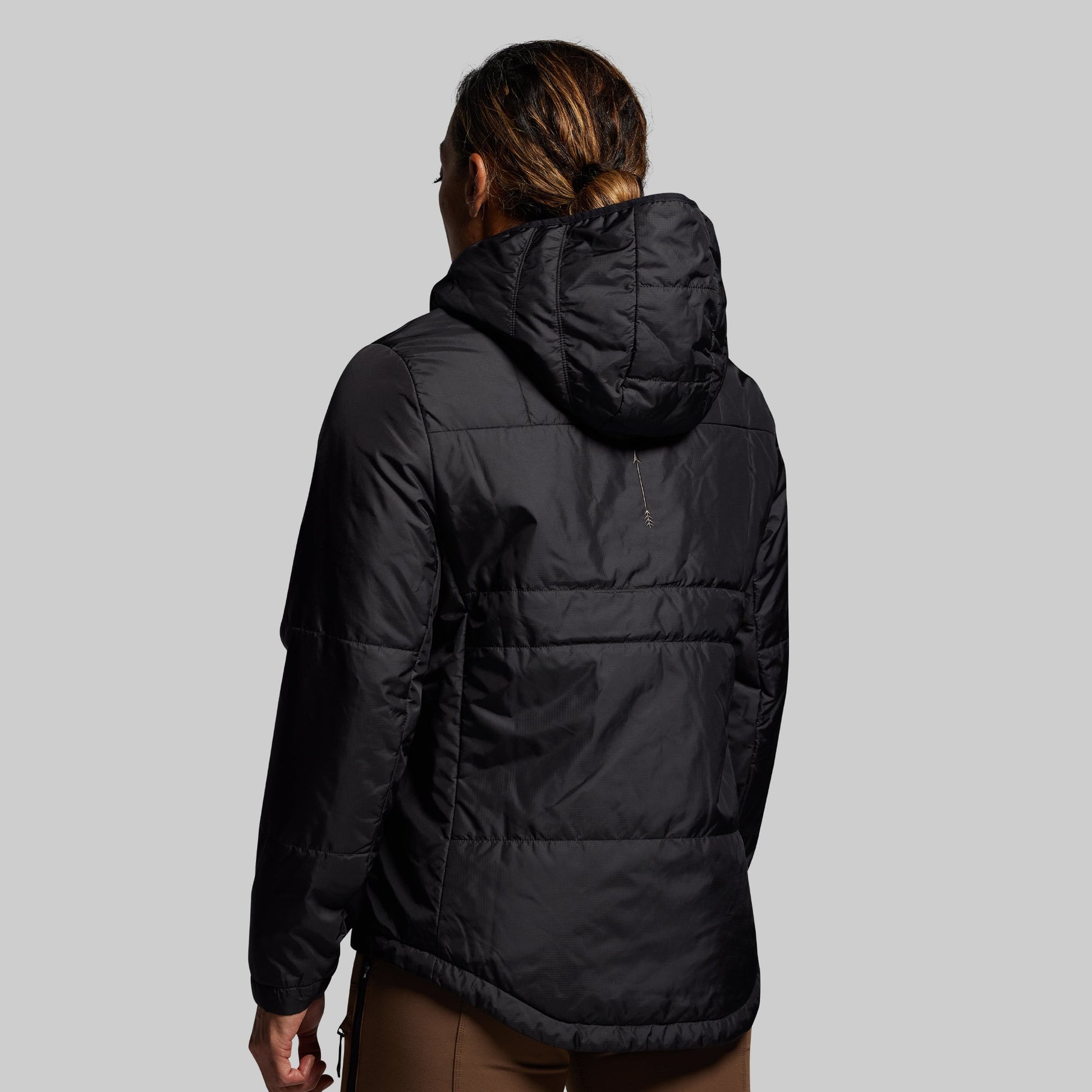 Person wearing a black puffer jacket on a gray background