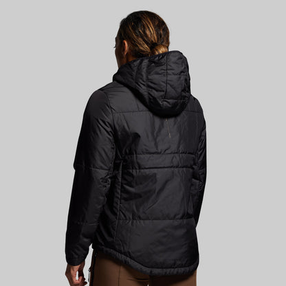 Person wearing a black puffer jacket on a gray background