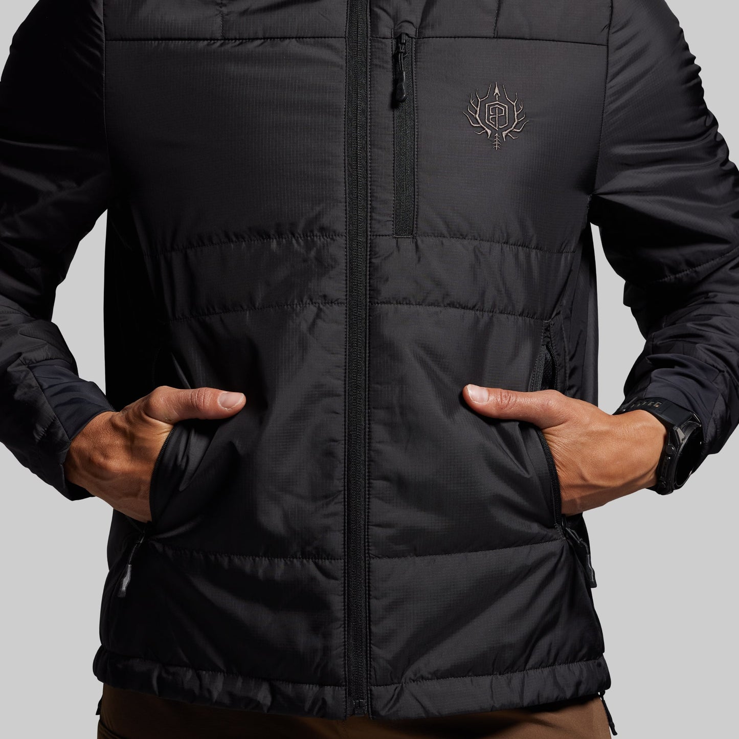 Black puffer jacket with a brand logo on a gray background
