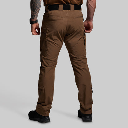 Brown tactical pants worn by a person on a gray background