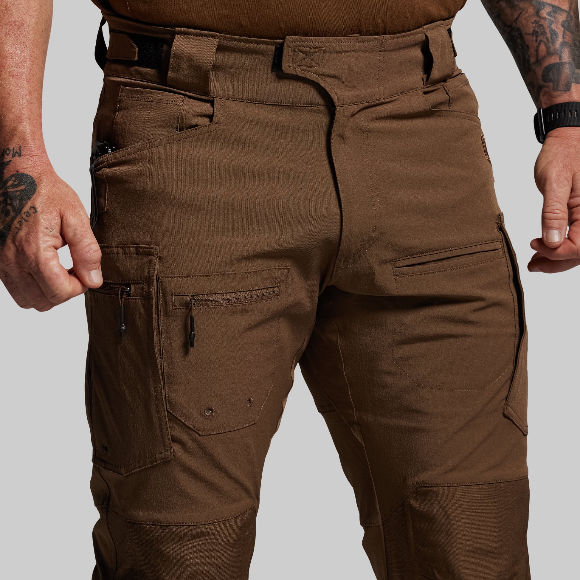 Brown tactical pants worn by a person on a plain background