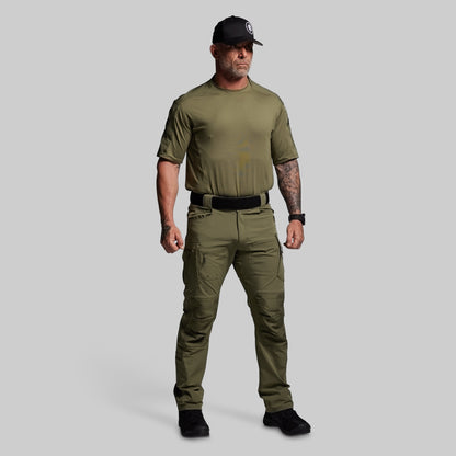 Man wearing olive green tactical outfit on a gray background