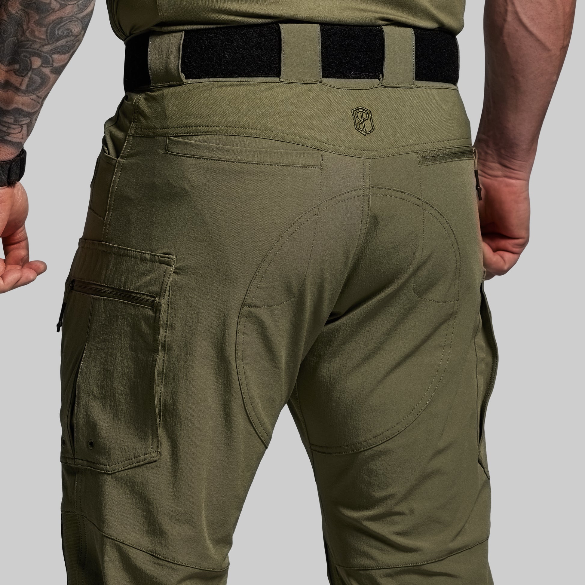 Olive green tactical pants with a visible brand logo on a gray background