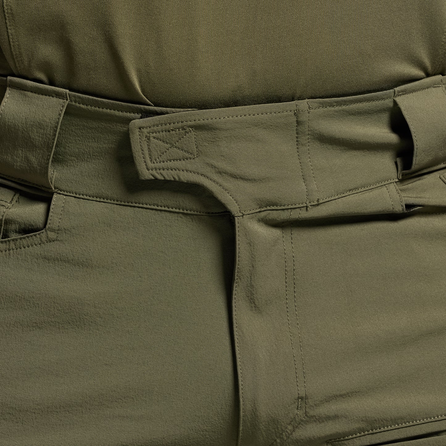 Close-up of green tactical pants focusing on the waistband.