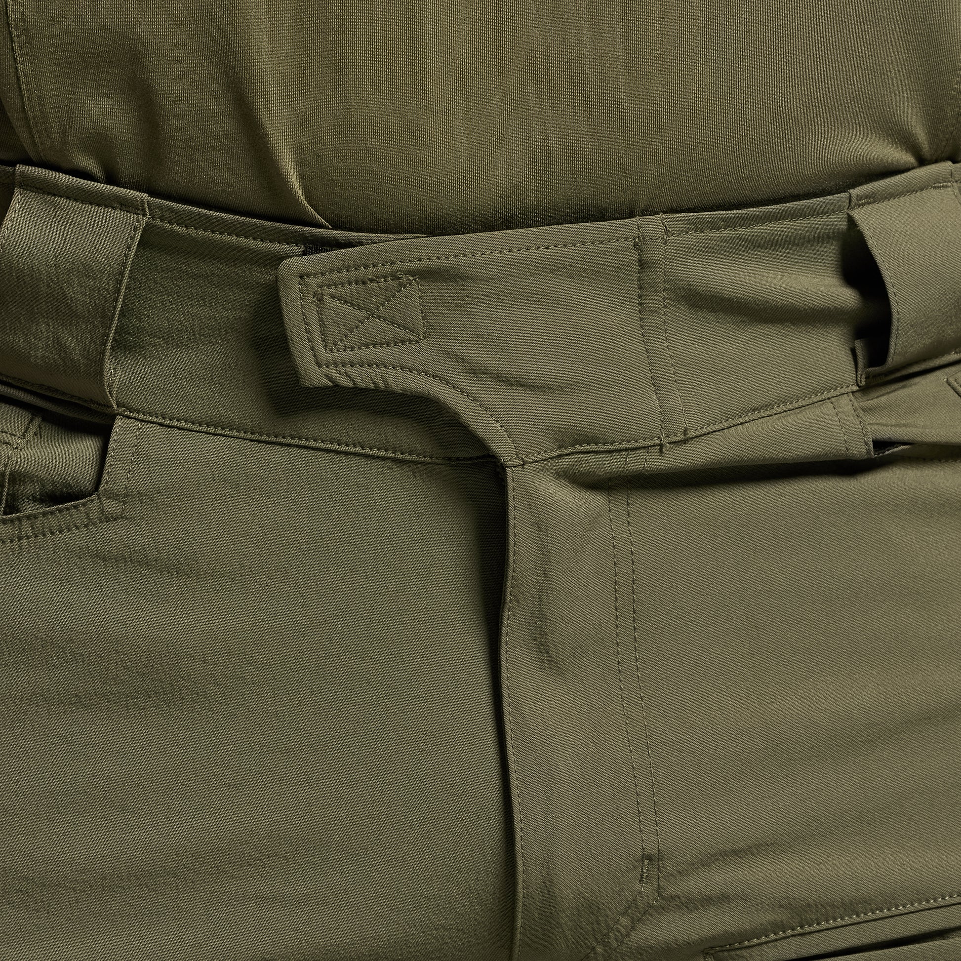 Close-up of green tactical pants focusing on the waistband.