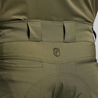 Close-up of olive green tactical pants with a brand logo on the waistband.