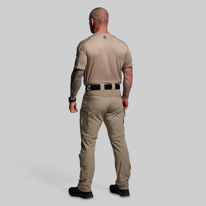 Man wearing a beige tactical outfit on a gray background