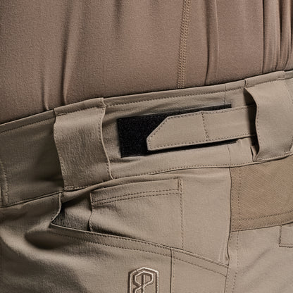 Close-up of a brown tactical pants with multiple pockets and a visible brand logo.
