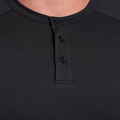 Close-up of a black henley shirt with buttons on a plain background