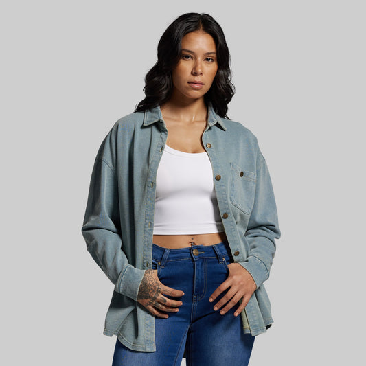 Woman wearing a denim shirt and blue jeans on a gray background