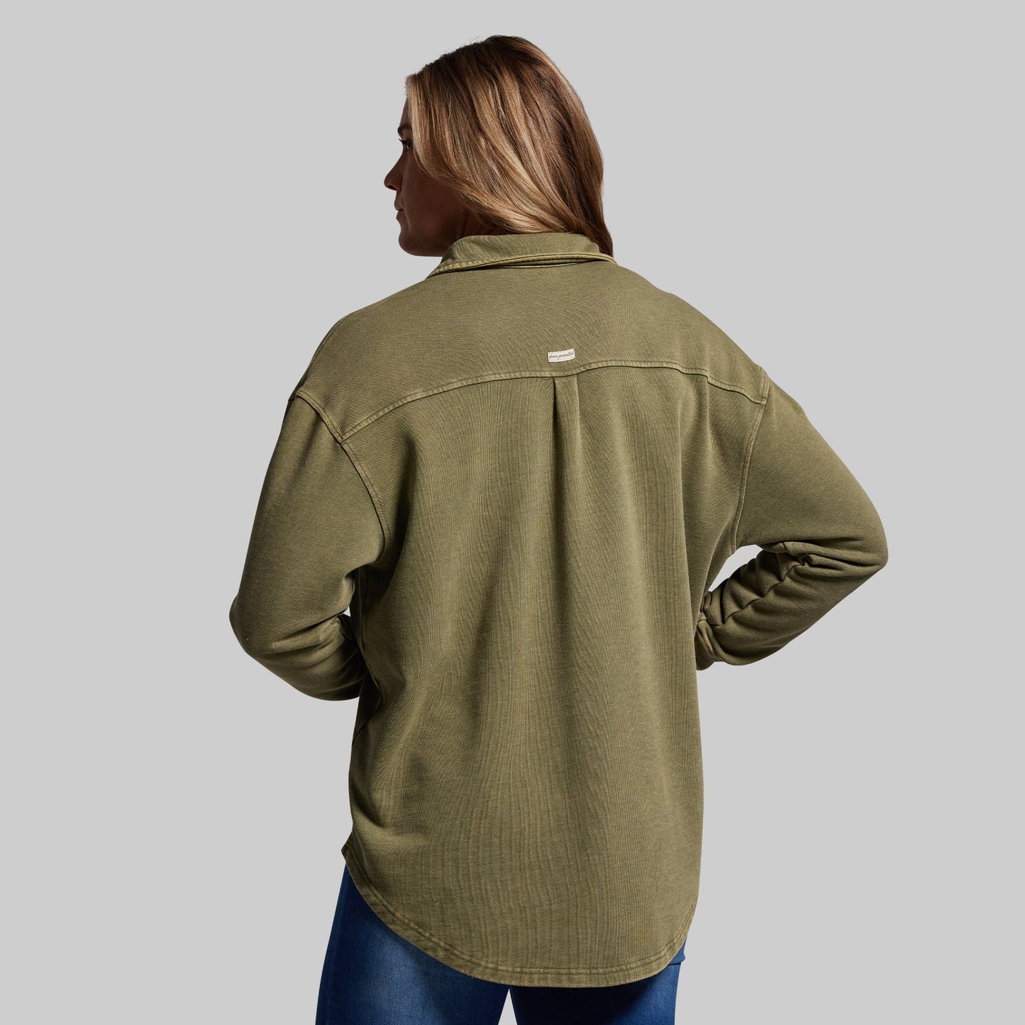 Person wearing a green shirt on a gray background