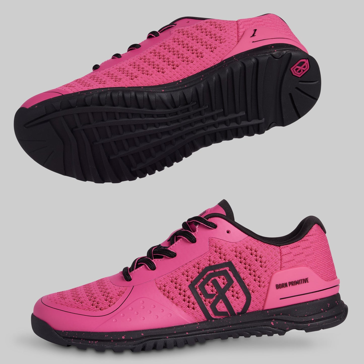 Pink athletic shoes with black soles on a gray background